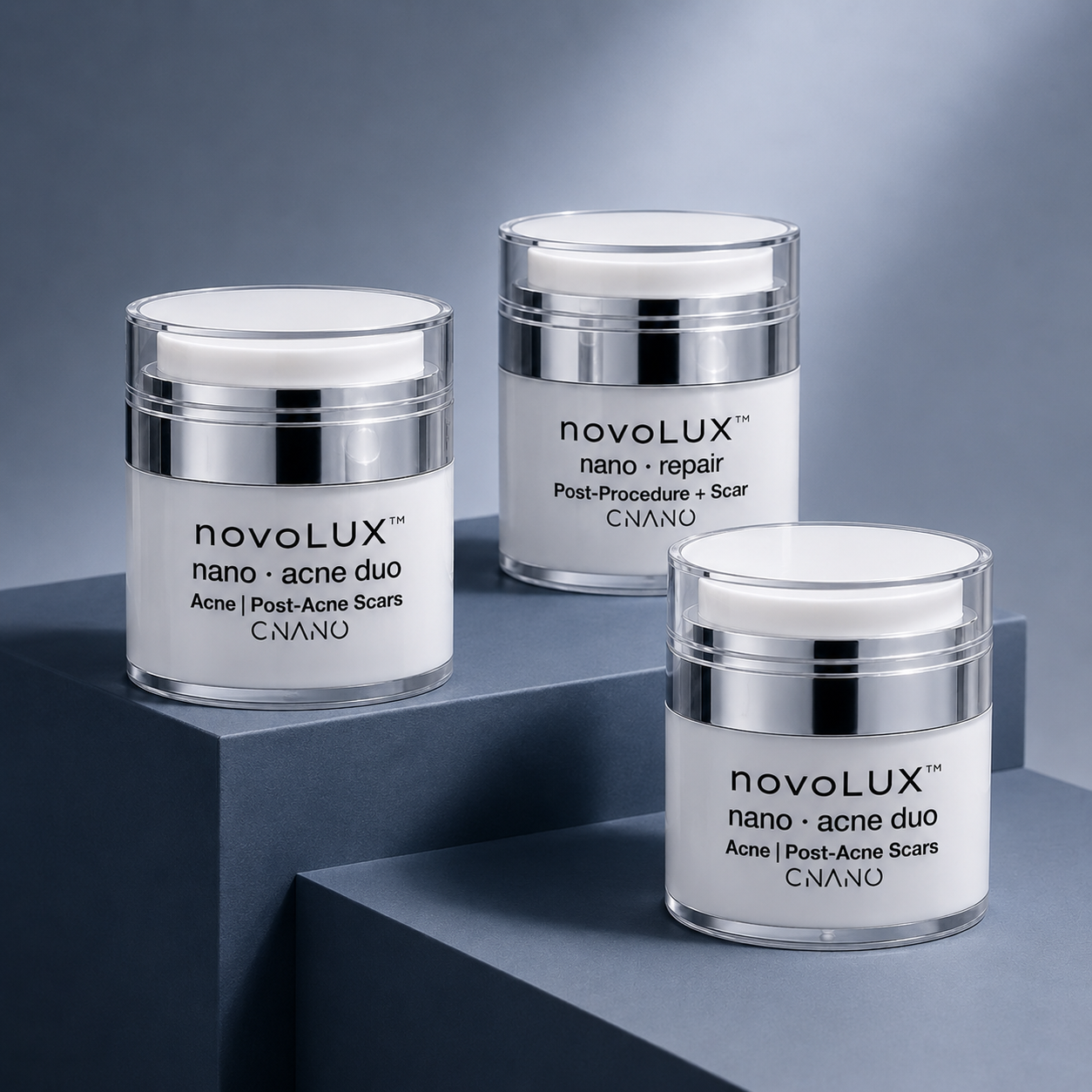 Three white and silver jars of CNANO nanoLUX skincare products arranged on dark gray geometric blocks against a blue-gray background.