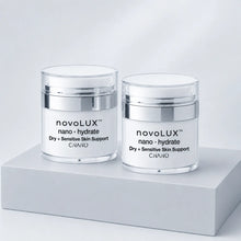 Two clear cosmetic jars with white lids and silver bands, labeled novoLUX nano hydrate, displayed on a light gray pedestal against a soft white background.