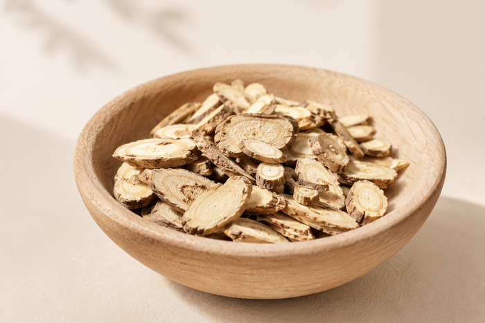 Wooden bowl filled with dried sophora roots on a beige background